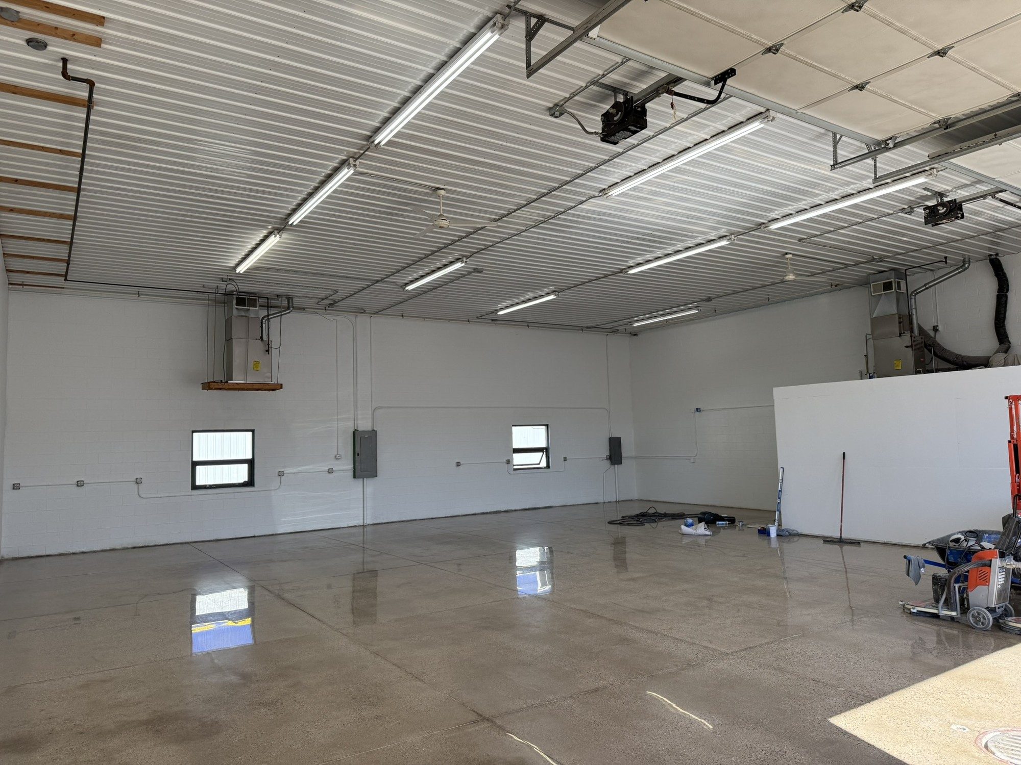 Large shop interior with a polished concrete floor and overhead lighting