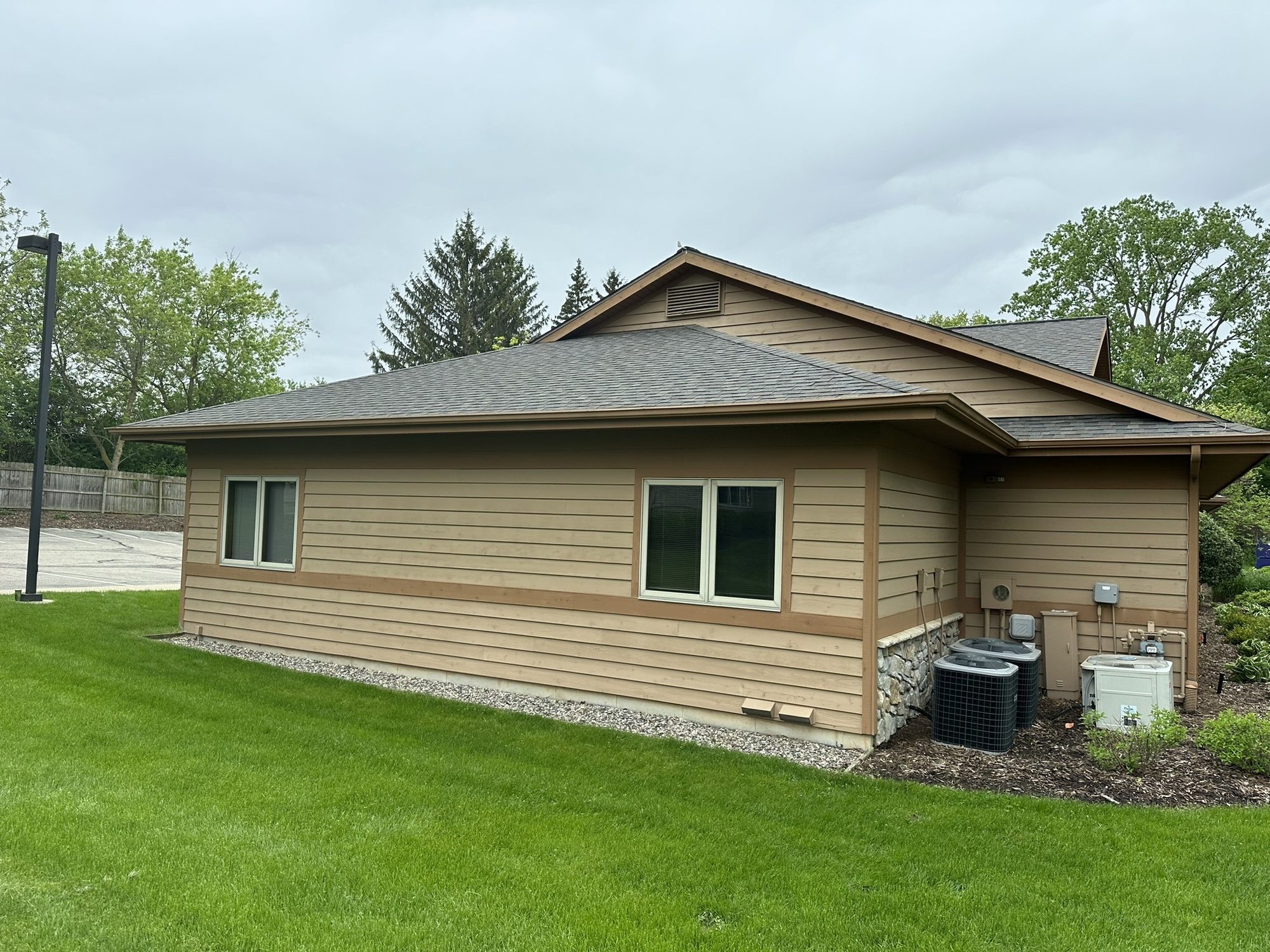 Single-story commercial building with tan siding and a landscaped lawn
