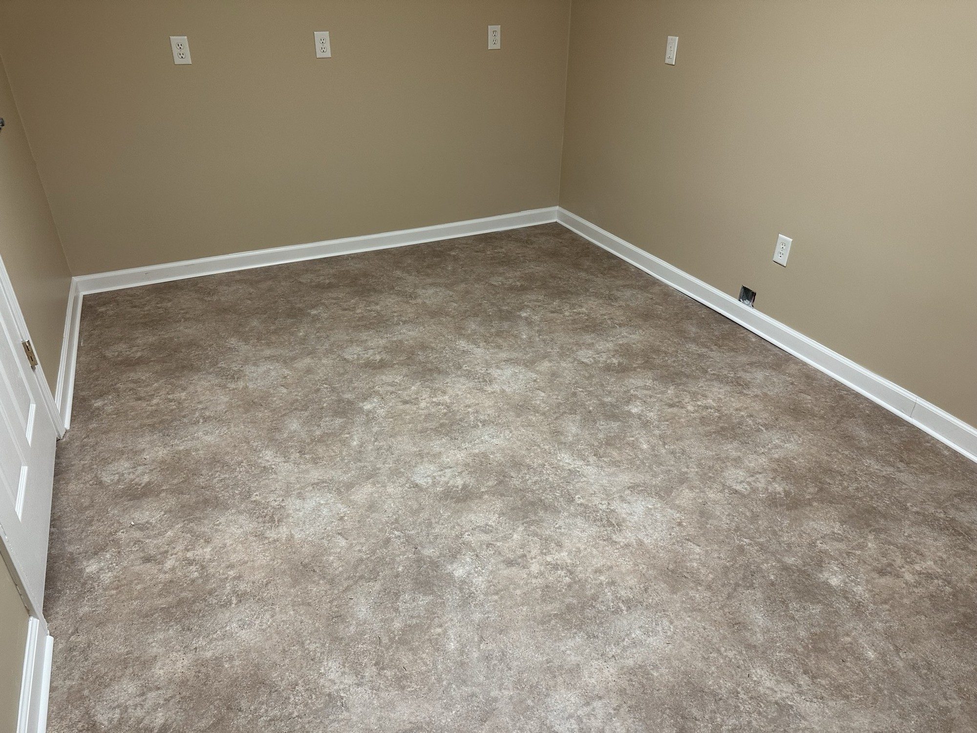 Stone-look glue-down rolled vinyl flooring in a finished room