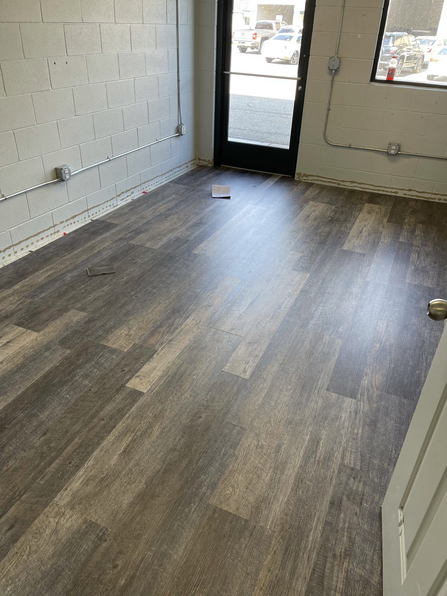 Gray weathered wood-look LVT near a glass entry door