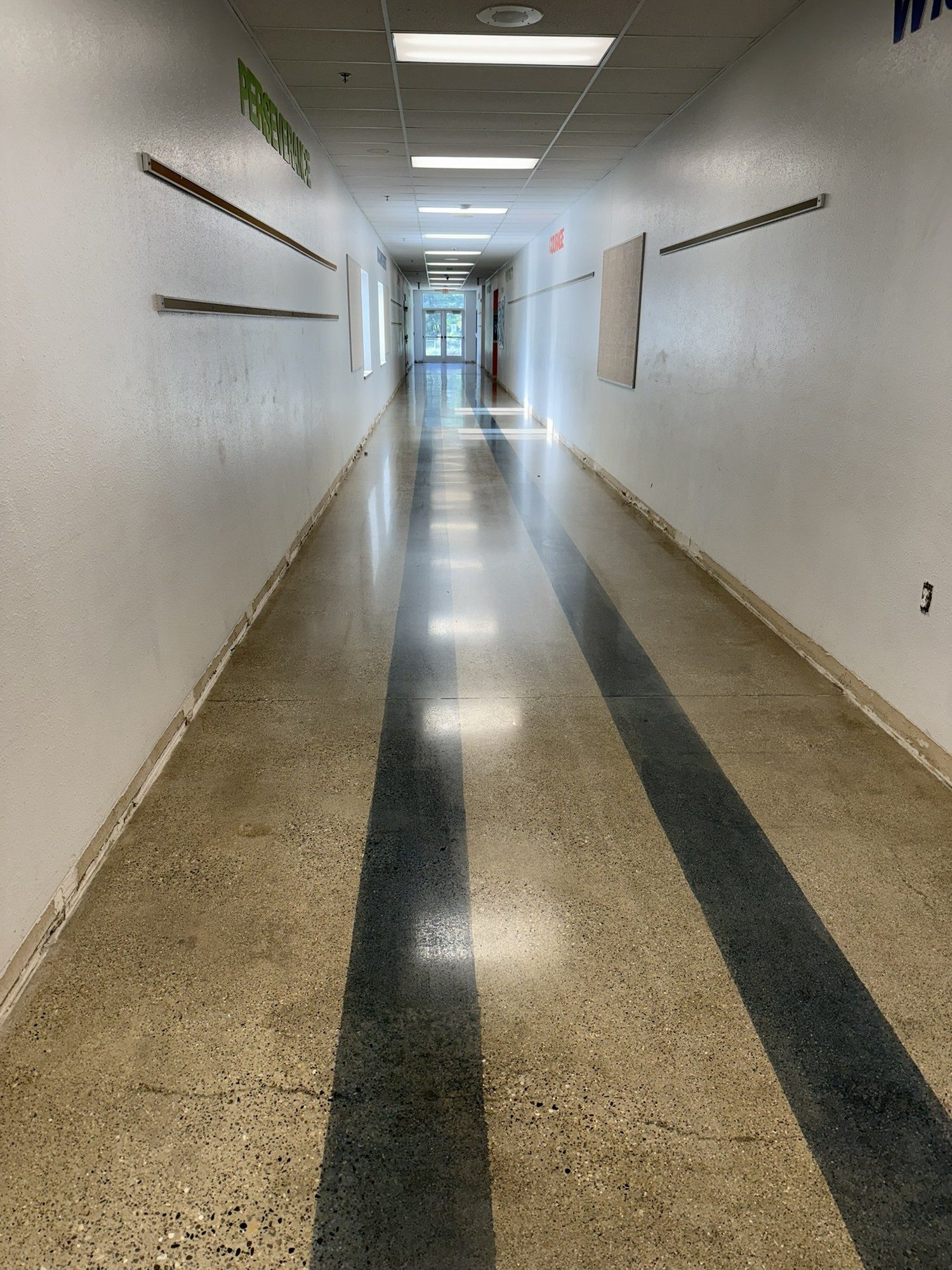 Polished concrete corridor floor with dark stripes